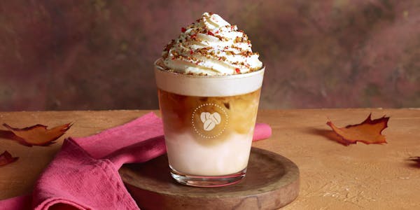 A Maple Hazel Frappe from Costa Coffee, standing on a wooden board. Available from Costa Coffee at Roadchef
