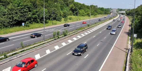Sunny UK motorway with a few cars driving on it